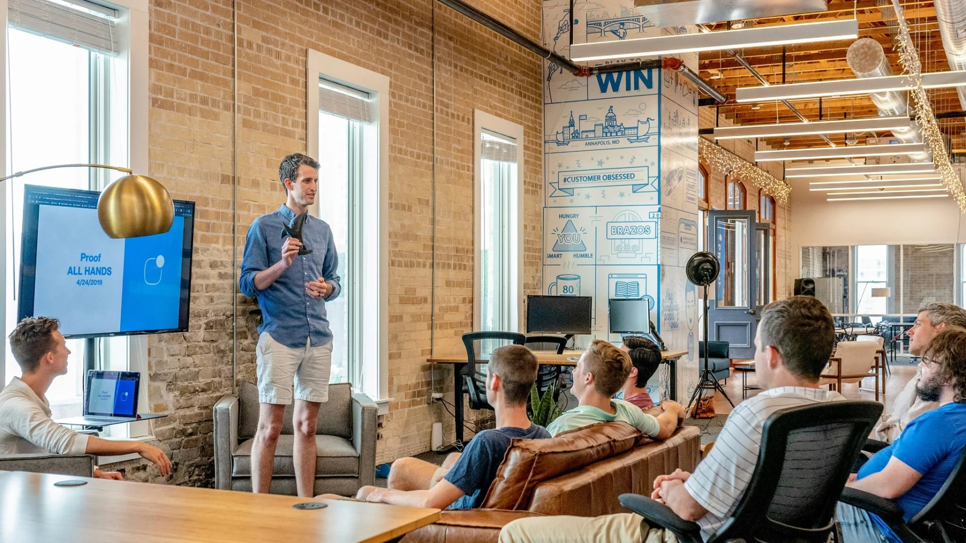 Presenter leading an agile software development workshop with a team in a modern office meeting space.
