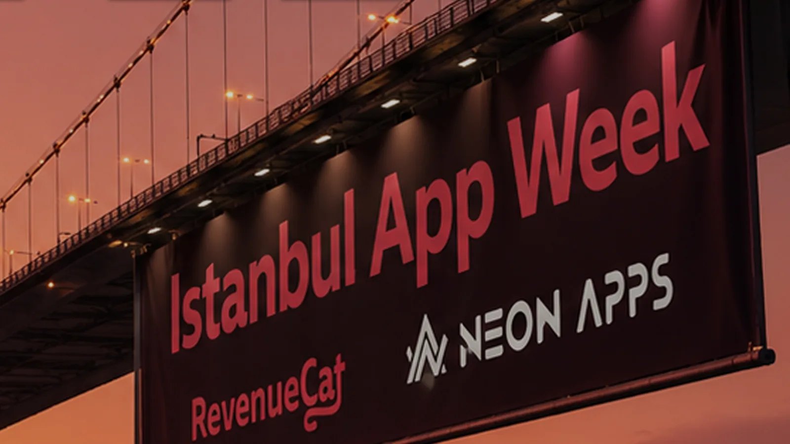 Istanbul App Week banner hanging from the Bosphorus Bridge at sunset, carrying the RevenueCat and Neon Apps logos