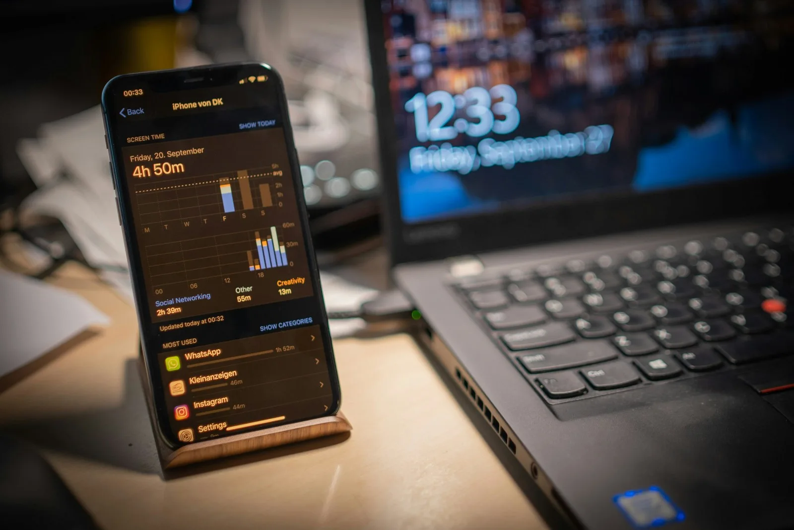 iPhone in a desk stand displaying a mobile app analytics screen next to a laptop illustrating Flutter cross-platform app development use cases
